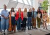 Group of people standing in a line for a group shot in an office.