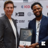 Two people holding an award
