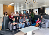group sitting on sofas or standing smiling at camera 